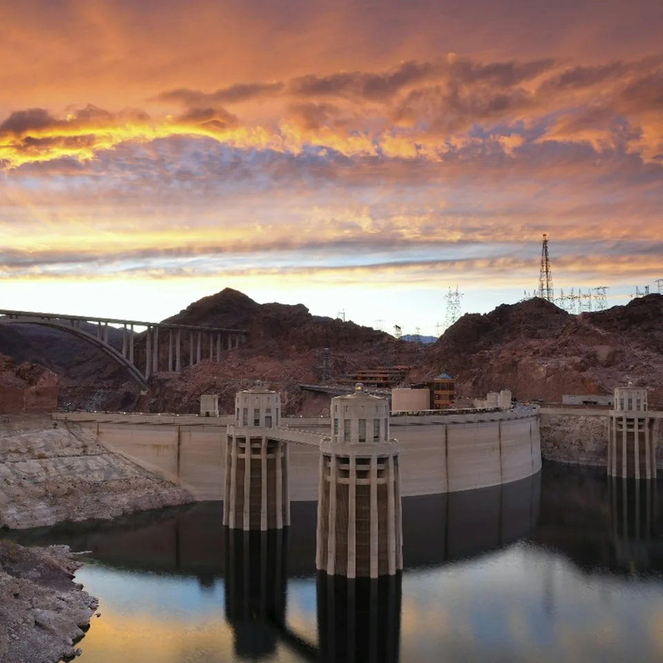 Hoover Dam beneath an orange sunset sky