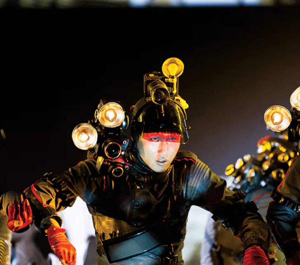 Michael Jackson ONE performer in a black and gold costume with illuminated props