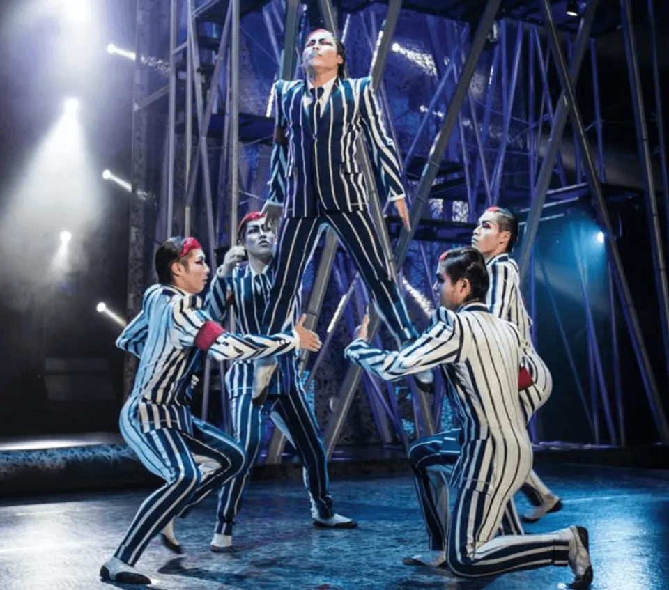 Michael Jackson ONE ensemble in striped suits beneath stage spotlights