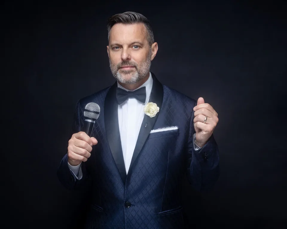 Steve Falcon holding a microphone in a promotional portrait