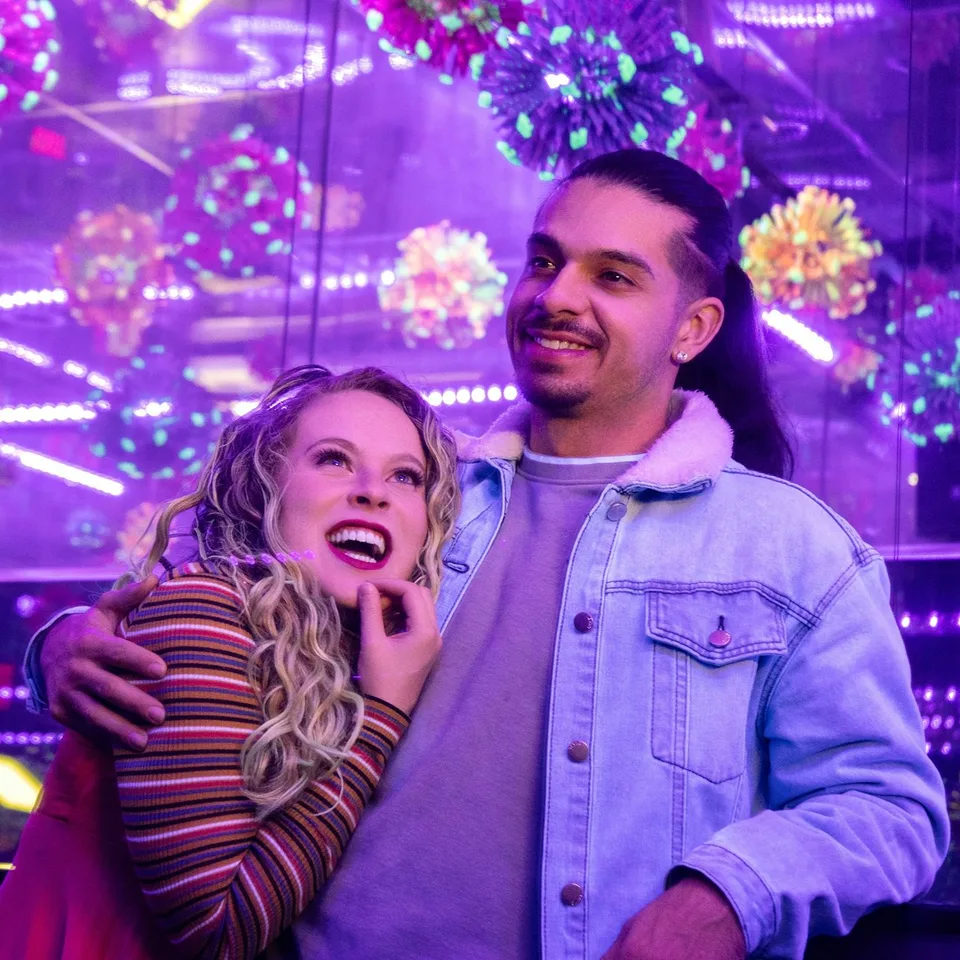 Visitors surrounded by purple lights at Wink World
