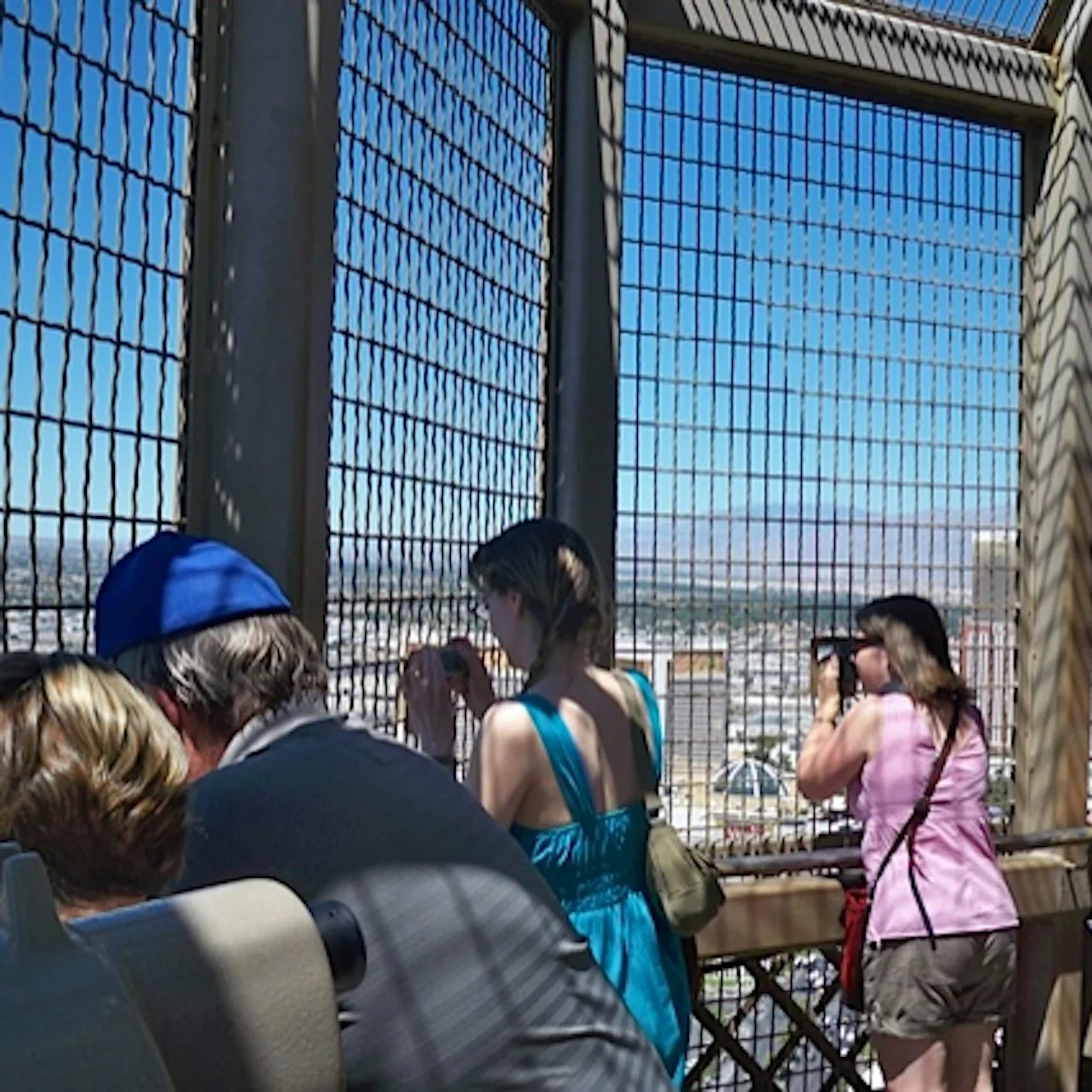 Visitors looking through the safety mesh of the Eiffel Tower viewing deck